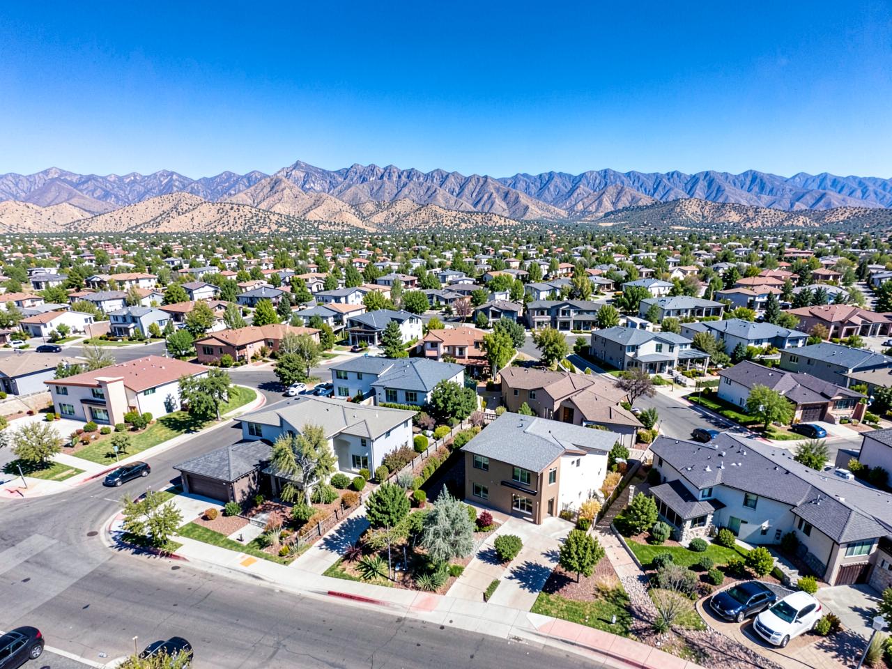 Aerial drone view of a neighborhood and mountains